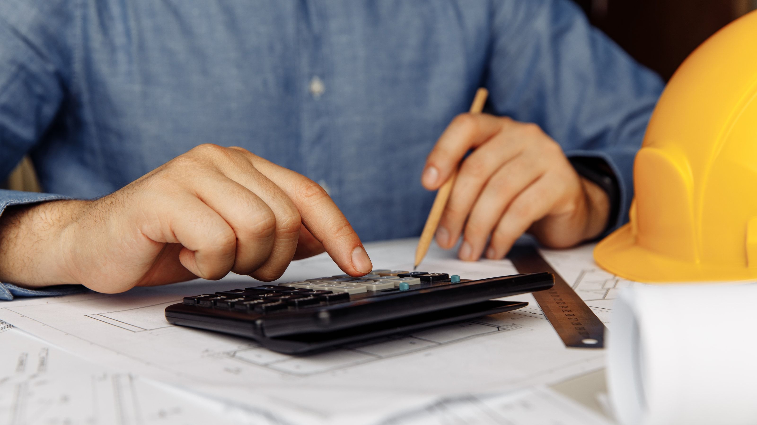Ingeniero usando una calculadora en un proyecto industrial